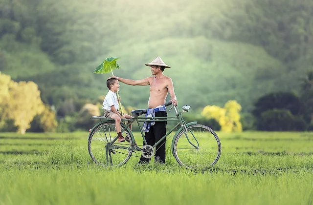 Pai e filho felizes na bicicleta