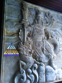 ukiran relief dari batu alam, batu putih atau juga biasa disebut batu paras jogja yang bermotif gambar  dewa kwan kong