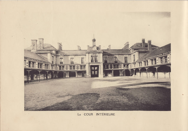 la cour est vide, le bâtiment l'encadre, des arcades permettent de s'abriter sur le pourtour en cas de pluie.