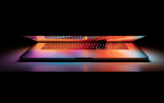 image of a laptop computer with rainbow light against a dark background
