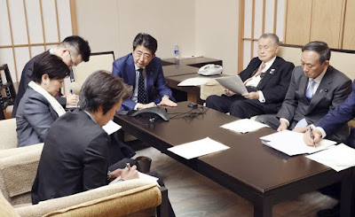 In a photo released by Japan’s Cabinet Public Relations Office, Prime Minister Shinzo Abe of Japan, center, participates with other leaders in a conference call with Thomas Bach, the I.O.C. president.