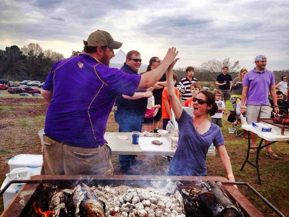 Jay Ducote and Aimee Tortorich congratulate each other on mastering the Cajun Microwave whole hog cookery.