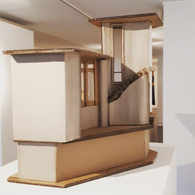 Front of a cardboard model of The Paterson House designed by Enrico Taglietti, on a plinth in an art gallery.