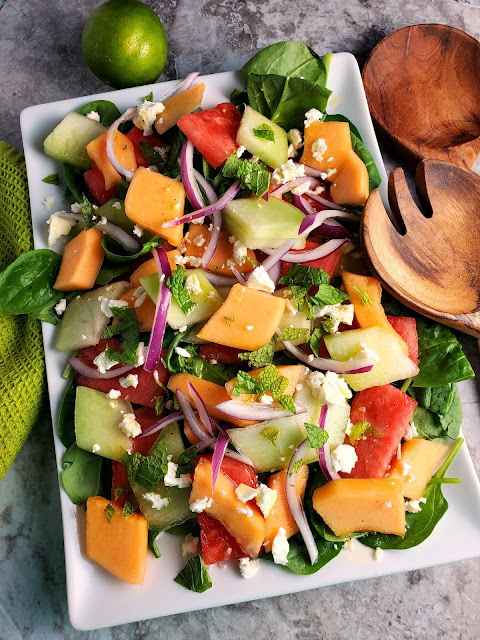 Refreshing Melon Salad:  Refreshingly cool and sweet melons mixed with onions and feta top a bed of baby spinach and doused with the most flavorful citrus garlic vinaigrette make one heck of a side dish! - Slice of Southern