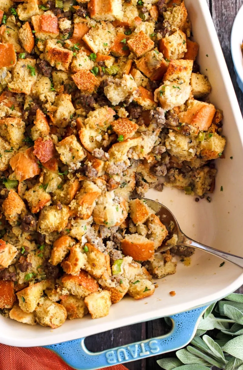 Top view closeup of Sage Sausage Stuffing in a baking dish on a rustic wood background.