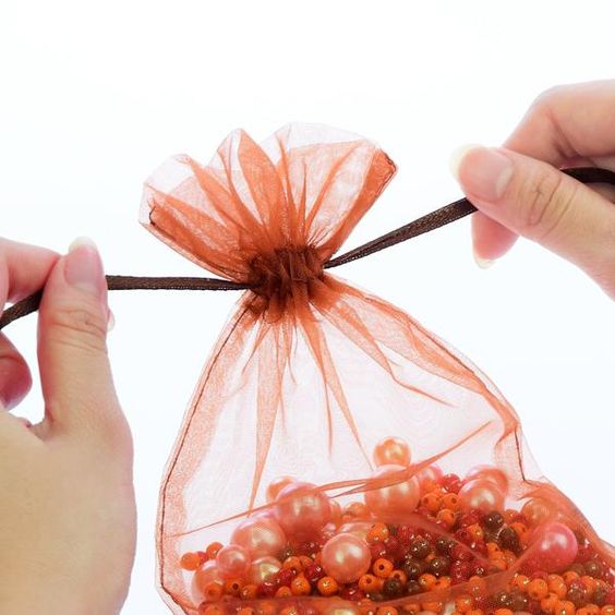 See-through drawstring pouch with beads inside.