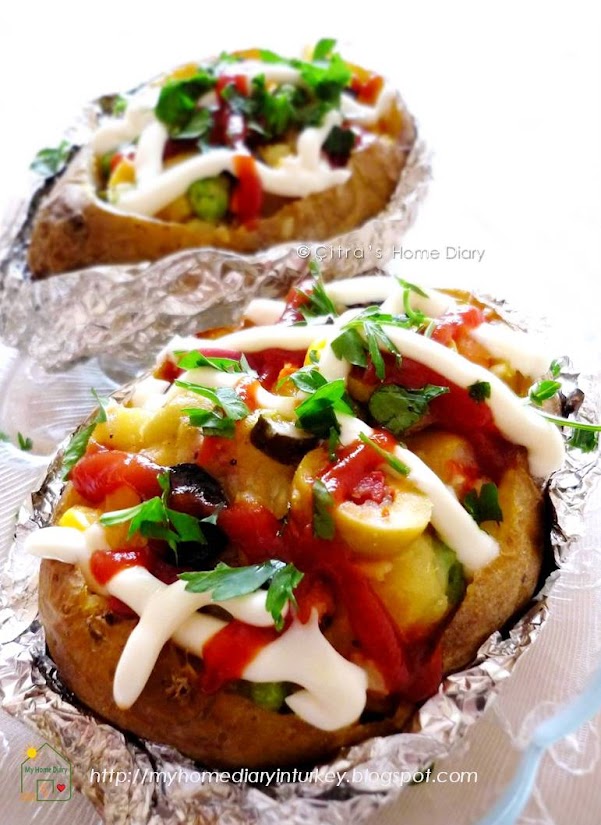 Kumpir / Turkish style Stuffed Baked Potato. You can vary the stuffing according to your taste, mostly are sausage, sweetcorn, olive, some pickles, some vegetables mix with cheese. Served hot, fresh from oven with ketchup and mayonnaise make this food become popular and everybody choice. Here I give you my recipe how to make it at home so you can experience Turkish taste in your dinner table.  #kumpir #Turkishfoodrecipe #resepmasakanturki #streetfood #turkishstreetfood #potato #stuffedpotato #lunchidea #vegan #citrashomediary #resepkentang #idfoodblogger #foodphotography #resepkentang