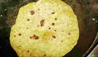 Cooking and roasting Missi roti on a pan