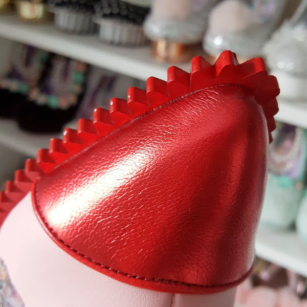 close up of red metallic pointed toe on ankle boot