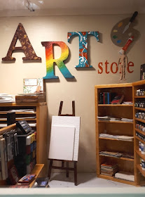 One-twelfth scale modern miniature art store displaying various paints, mark-making material, books and supports.