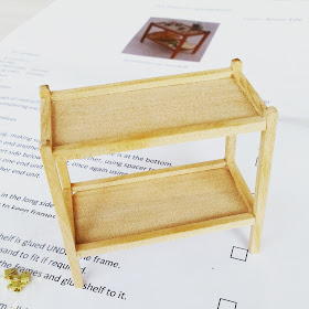 A half-finished one-twelfth scale tea trolley sitting on the instruction sheet.