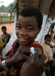 Mbuti woman of the Ituri Rainforest in equatorial Africa receives an immunization shot