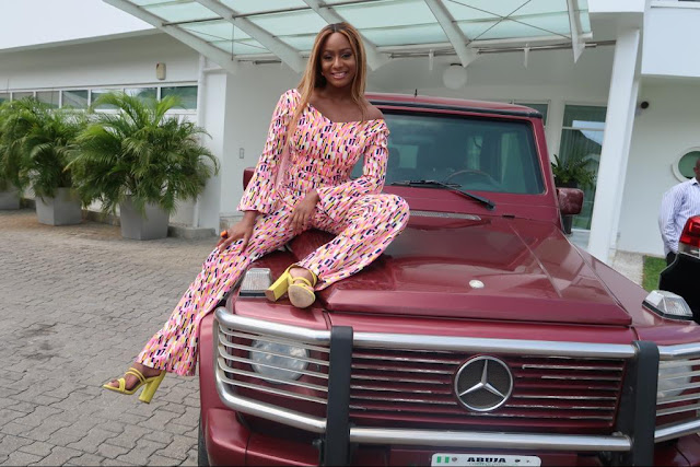 Billionaire daughter, Dj Cuppy poses in jumpsuit beside her bullet proof G-Wagon