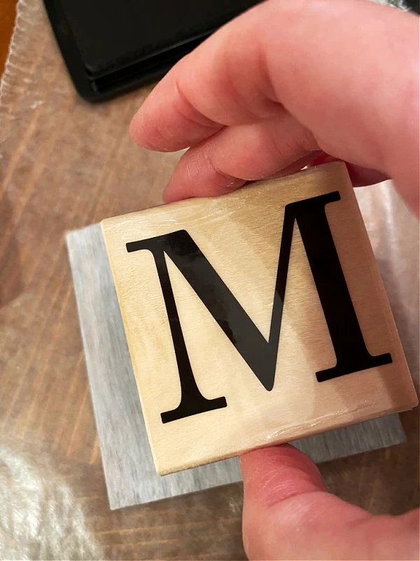 Monogram M Stamp being placed on a tile