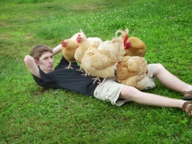 Un joven posando con gallinas 