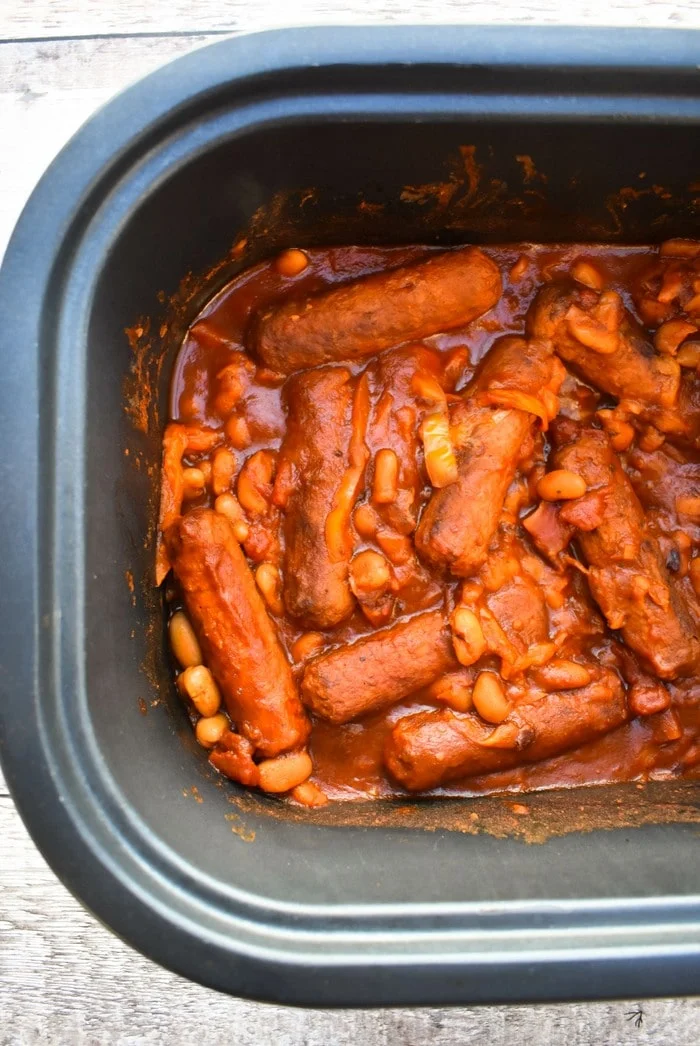 a close up of sausage stew in a slow cooker bowl