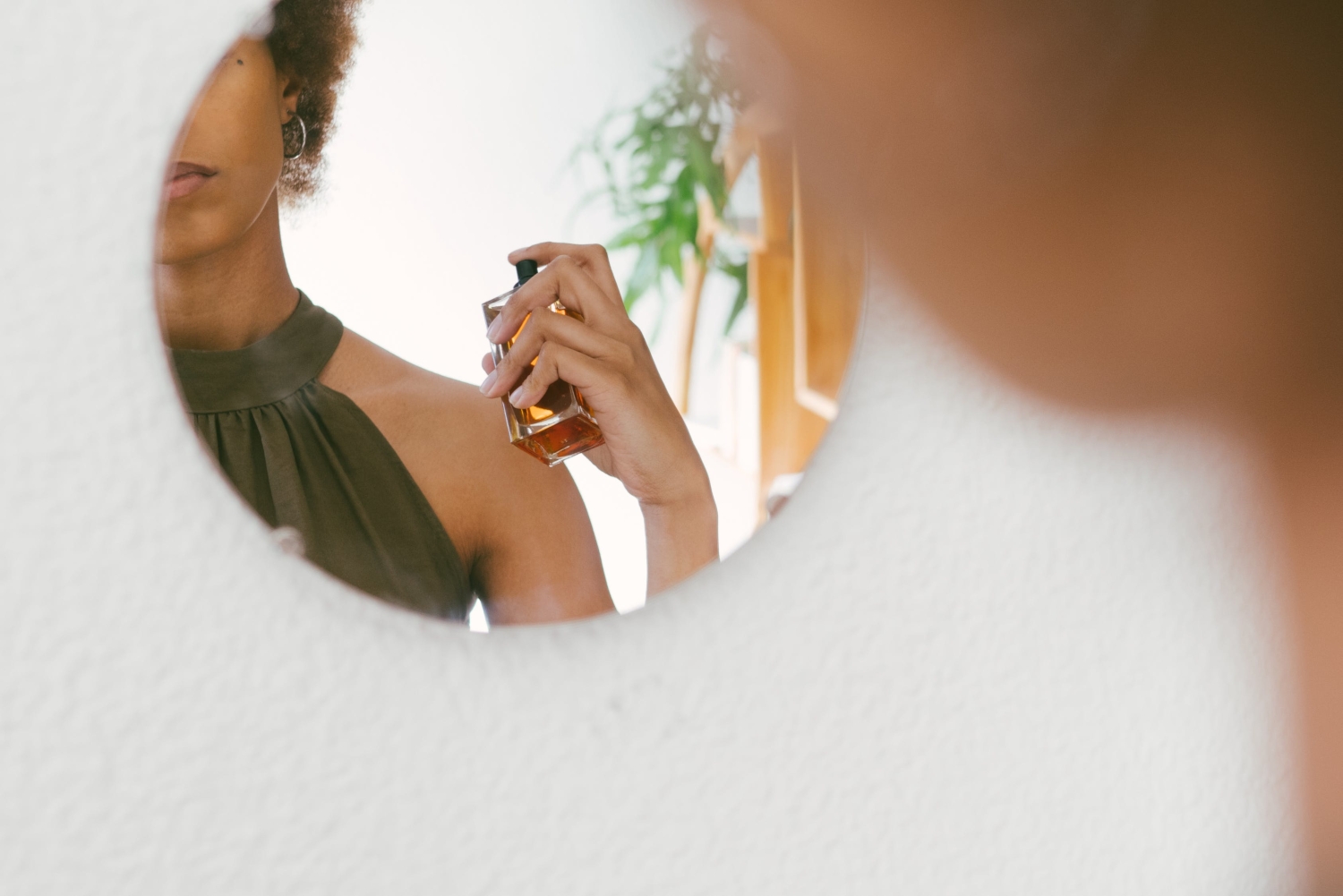a reflection of a woman who uses perfume