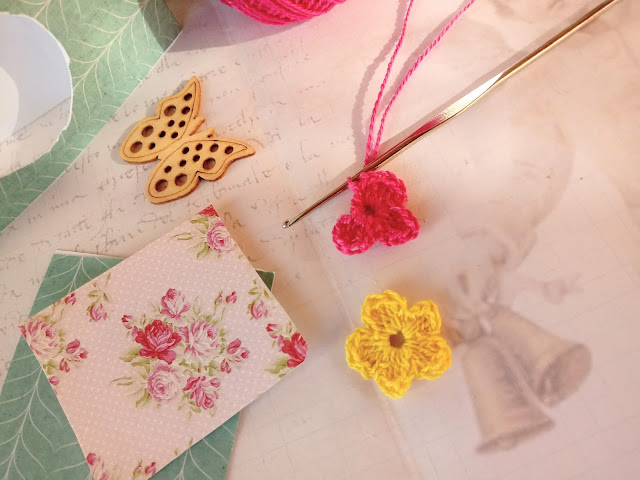 Idea para hacer etiquetas colgantes con flores prensadas, florecitas de ganchillo y botones de mariposa