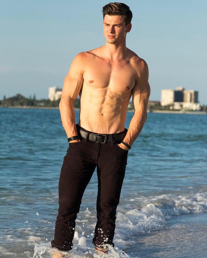 handsome-fit-shirtless-male-model-muscle-pecs-black-jeans-wet-feet-sea