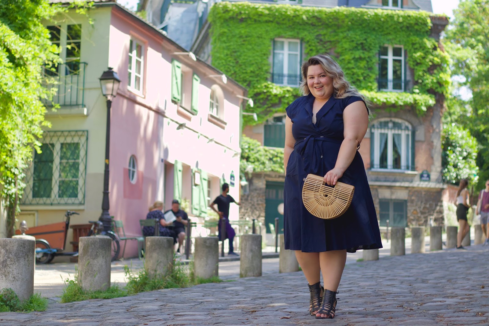 Chicago Plus Size Petite Fashion Blogger, influencer, YouTuber, and model Natalie Craig, of Natalie in the City, wears City Chic's fit and flare midi dress from Dia & Co while visiting this cute pink restaurant, La Maison Rose in Paris, France.