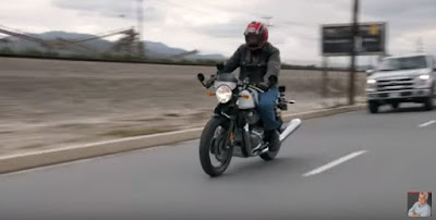 Jay Leno riding a Royal Enfield motorcycle.