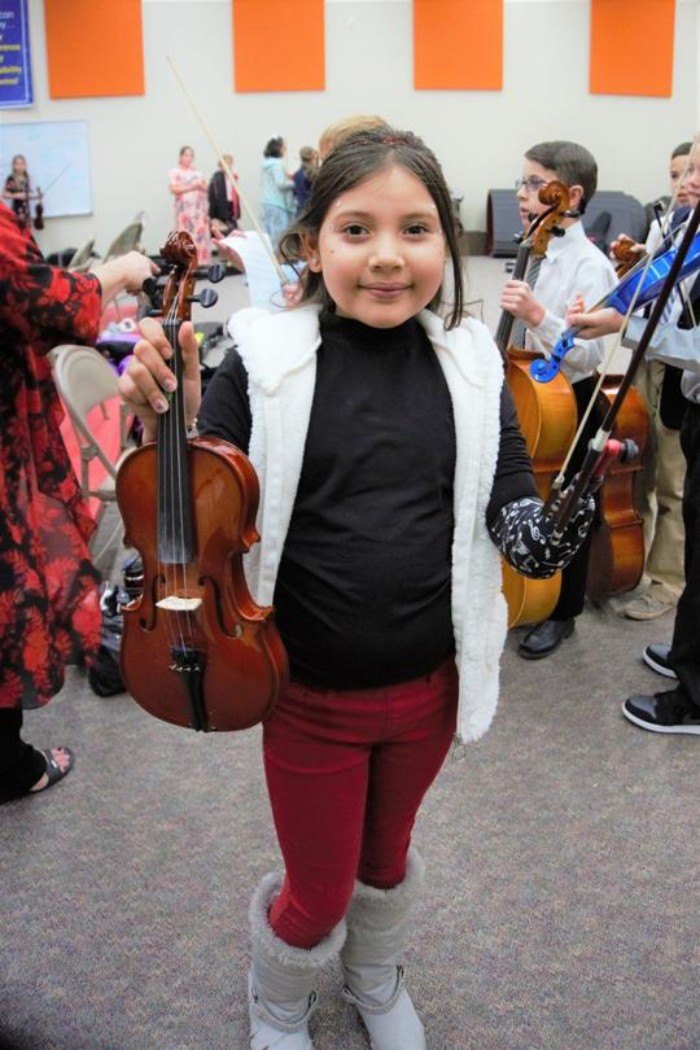 child with a prosthetic limb playing the violin