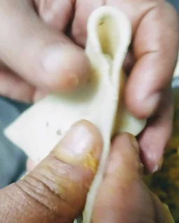 Sealing the edge of the pastry for samosa recipe