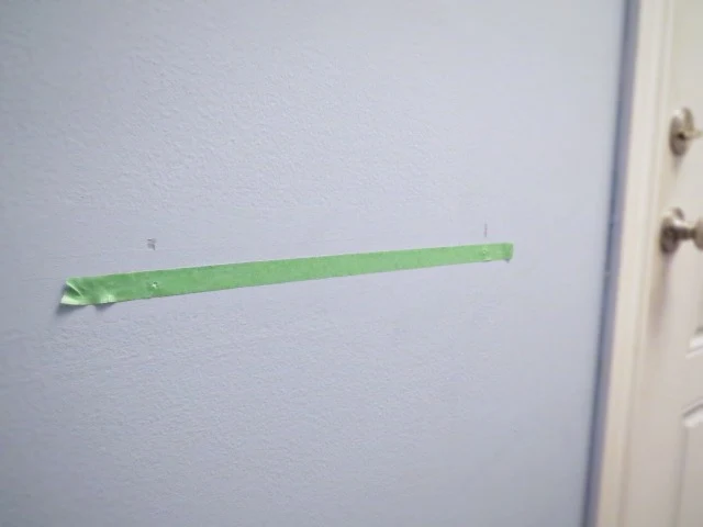 tape on wall for bracket holes