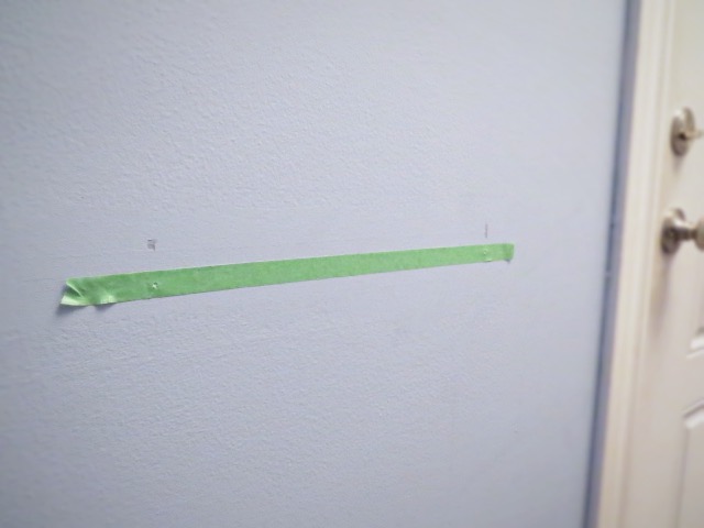 tape on wall for bracket holes