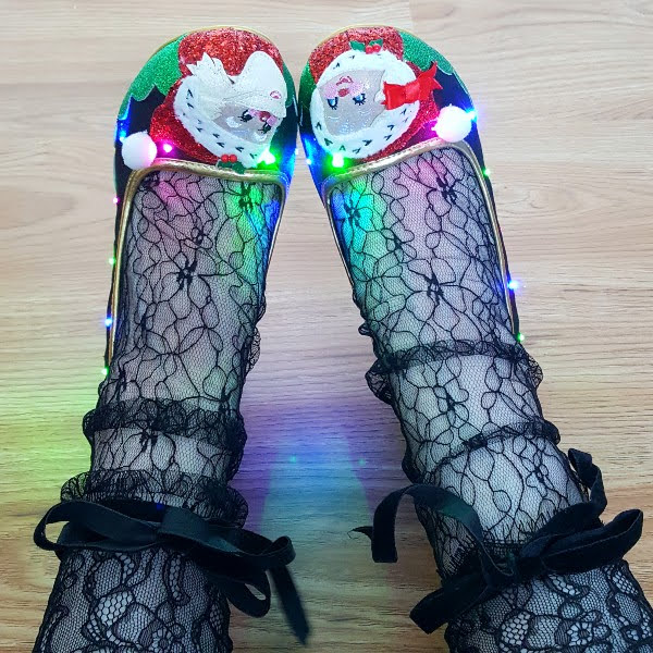 festive shoes on feet with multi coloured flashing lights and black lace socks