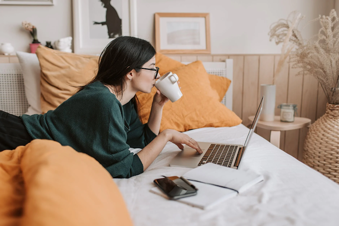Mulher usa notebook na cama enquanto bebe café | Foto de Vlada Karpovich via Pexels
