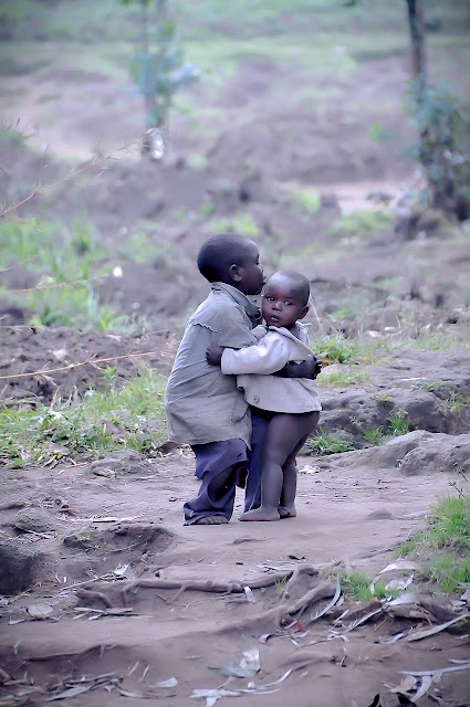Imagen de dos pequeños niños africanos cuidándose mutuamente.