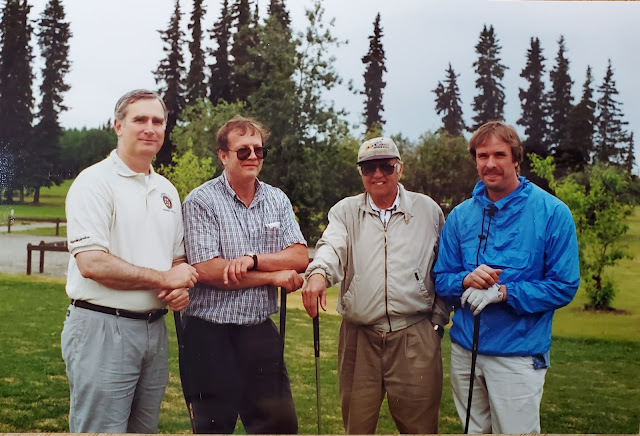 image four men leaning on their golf clubs
