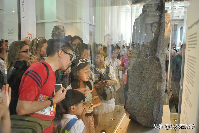Толпа посетителей осматривает Розеттский камень в Британском музее.
