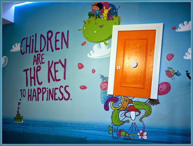 Pared pintada con el mensaje "Los niños son la llave de la felicidad"