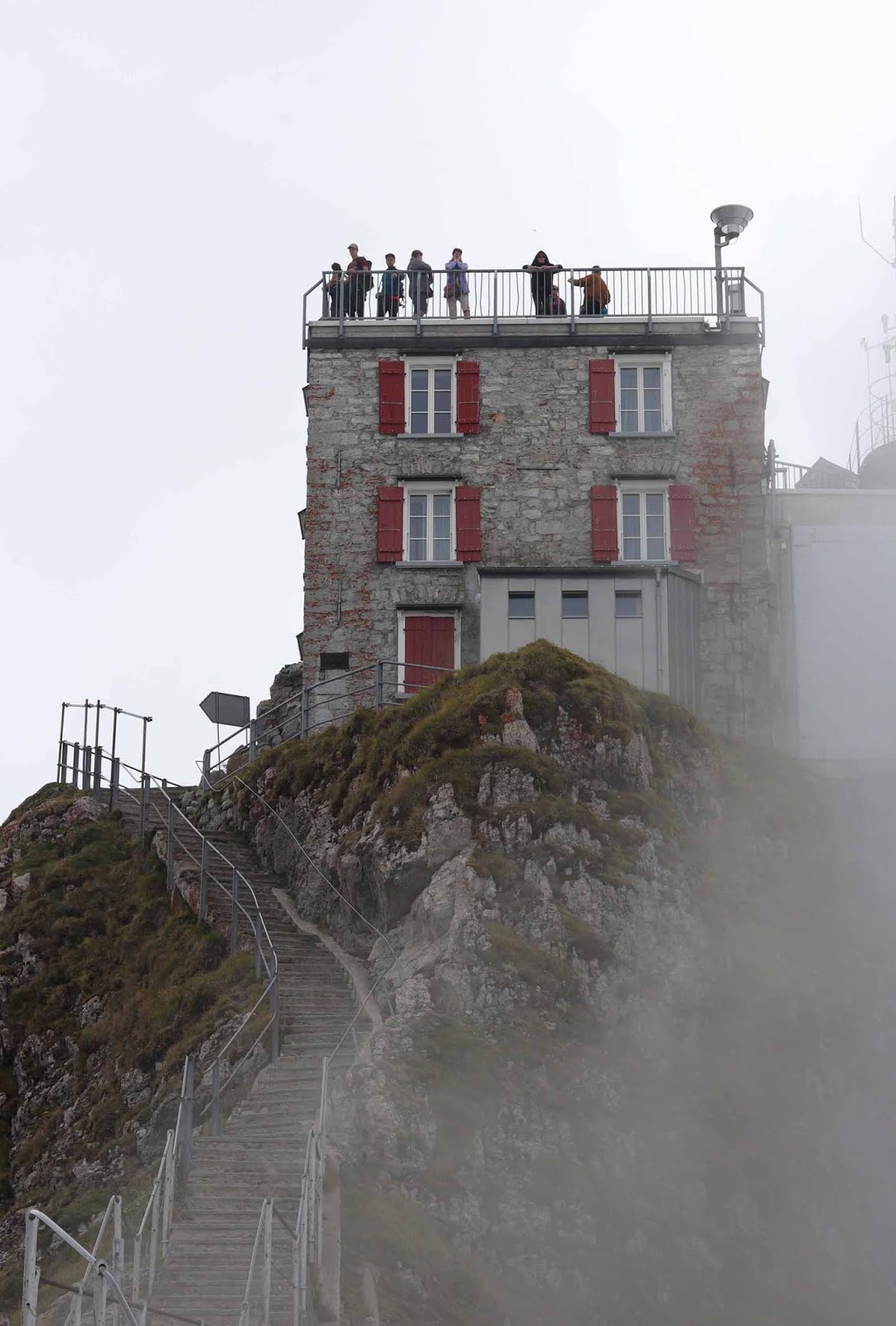 Ihmisiä katolla ja rappuset harjanteella Ihmisiä katolla ja rappuset harjanteella