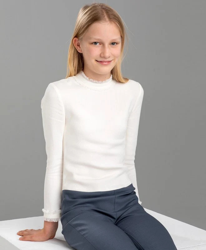 Leonore wore an ivory long sleeve fringed cuff and neck pullover cashmere sweater