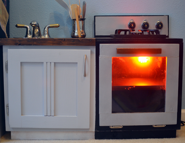 This little play kitchen was made from old cabinets and includes electricity for a fake oven and stovetop!