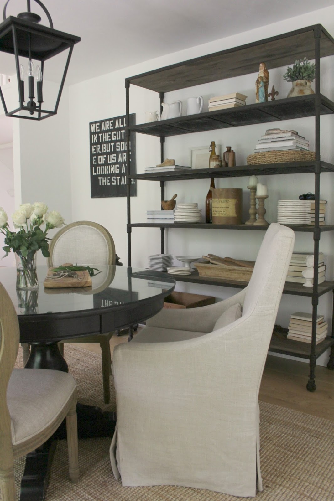 Belgian style dining room with industrial shelves and round table - Hello Lovely Studio.