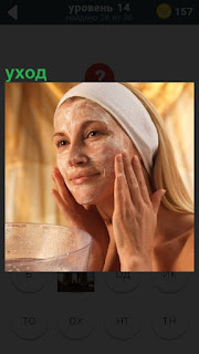 Женщина руками наносит крем на лицо, уход за кожей и повязка на волосах