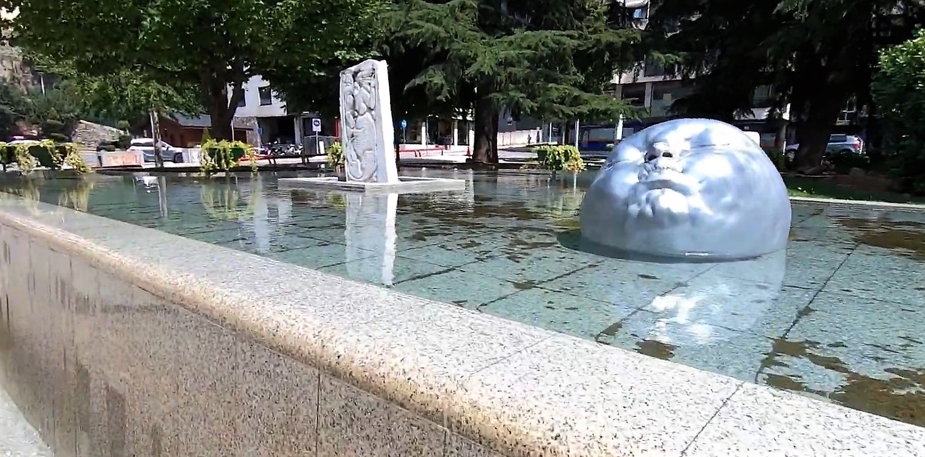 Sculpture of a head laying in a fountain
