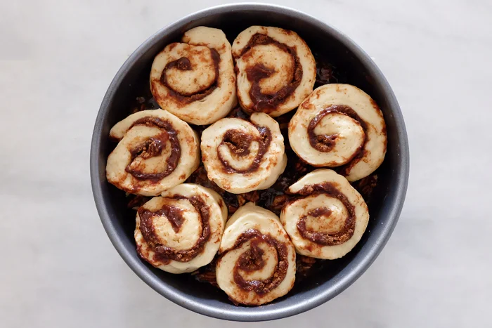 cut sticky buns risen in pan ready to bake