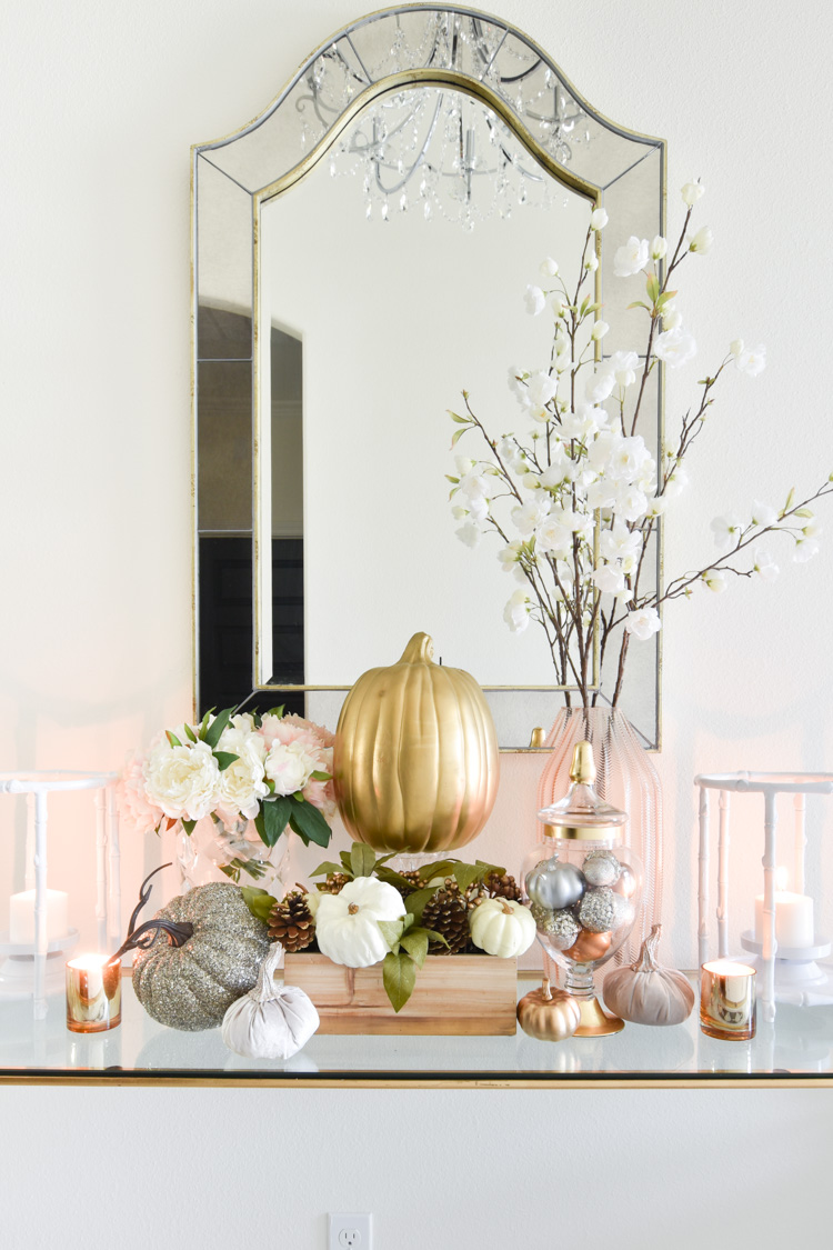 Faux florals, white, gold and silver pumpkins and white cherry blossoms create a feminine fall decor vignette.