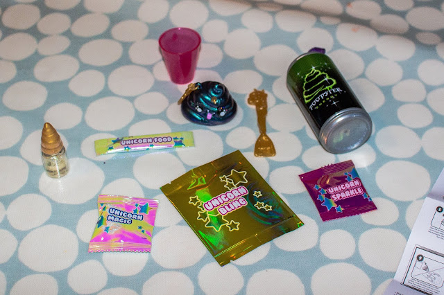 Inside Poopsie Poop Pack drop 2 you get: a play drink container, measuring cup, keychain, spoon, scent in a bottle, unicorn food, unicorn magic, unicorn bling and in ultra rare ones unicorn sparkle