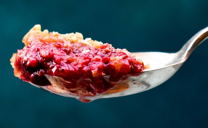 Blackberry cepat hancur Tampilan dekat dari sesendok crumble blackberry