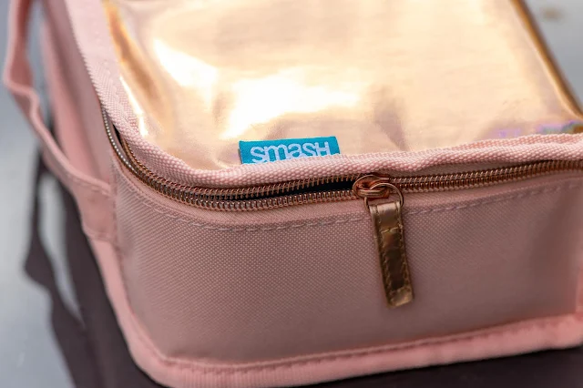 Iridescent rose gold lunch bag close up showing material and zip and SMASH label
