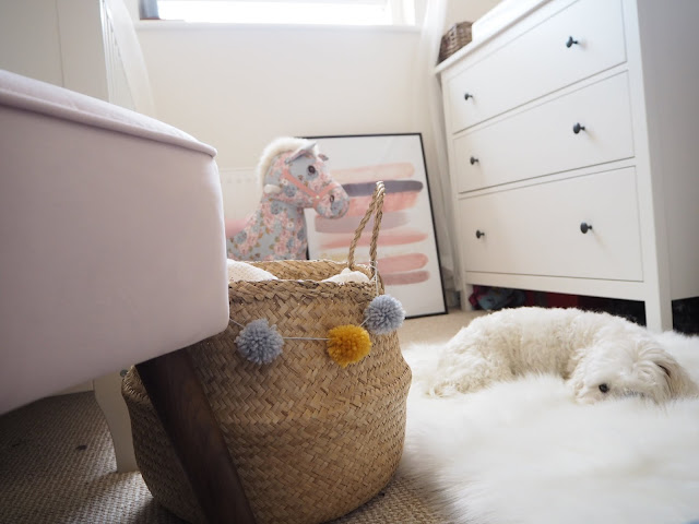 Nursery bedroom perfect for a baby girl toddler. Pink and swan ballet themed room with a sunburst mirror, feather lampshade, pom pom basket and liberty print rocking horse