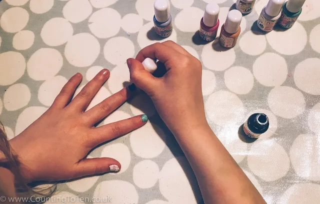 An overhead shot of my daughter painting her nails all different colours
