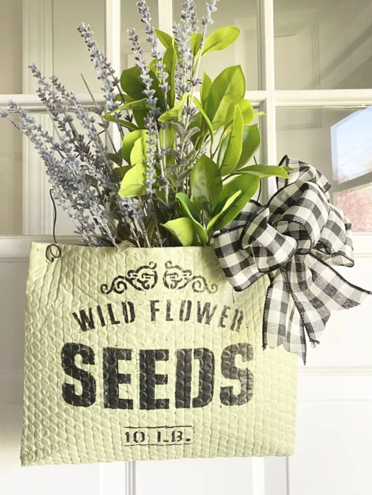 flower basket on front door with flowers and bow