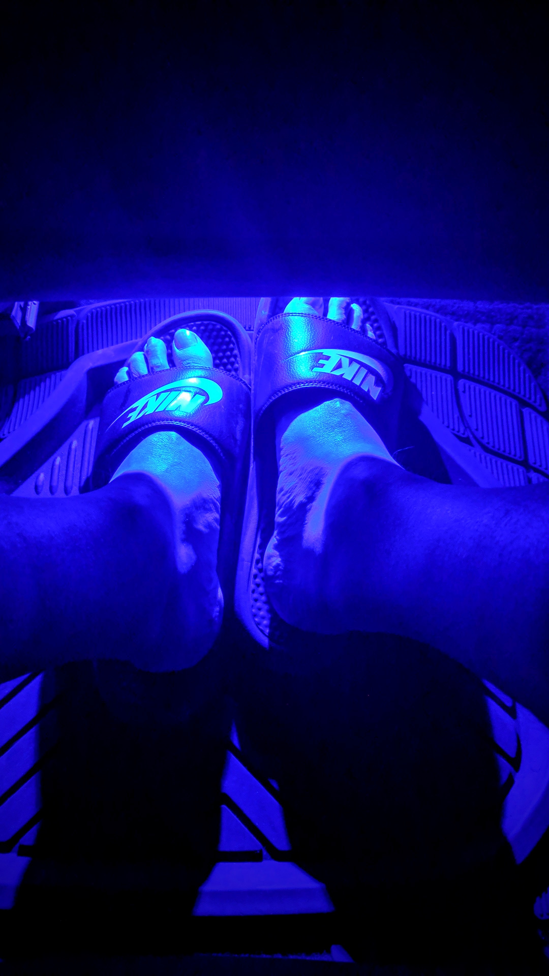 Feet under a blue lit seat